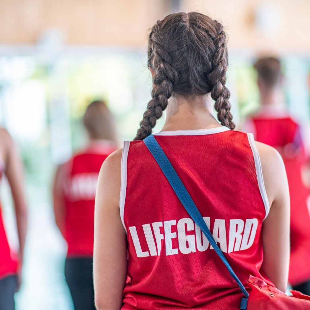 Picture of a you woman's back with lifeguard written on her shirt.